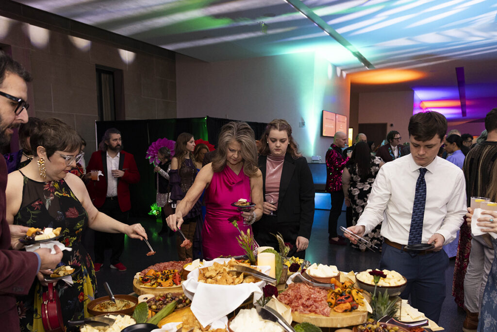 Attendees fill their plates with charcuterie and hors d'oeuvres.
